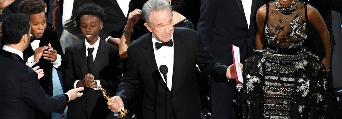 Actor Warren Beatty (C) explains a presentation error which resulted in Best Picture being announced as 'La La Land' instead of 'Moonlight' onstage during the 89th Annual Academy Awards at Hollywood & Highland Center on February 26, 2017 in Hollywood, California.  (Photo by Kevin Winter/Getty Images)