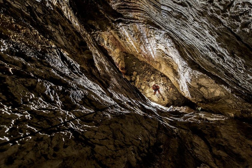 Zhenya Tsurikhin climbs a freehanging rope. Dark Star’s passages are deep underground, yet many are 10,000 feet above sea level. The thin air at that altitude ups the physical challenge of negotiating the cave. (Robbie Shone/National Geographic)