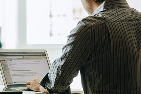 Caucasian businessman using laptop in office (Getty Images)