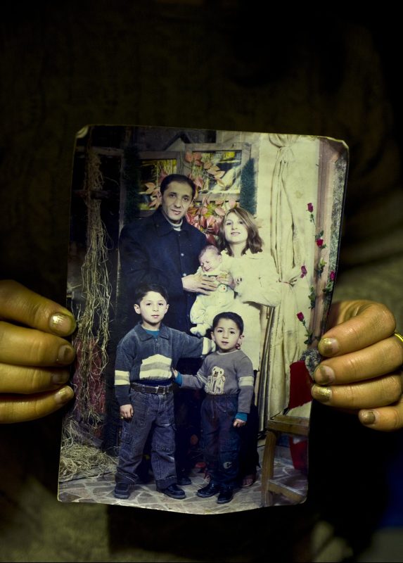 In this Thursday, Jan. 19, 2017 photo, Fidan Kiru, 31, a Syrian refugee from Afrin, holds a photograph taken in 2004 showing herself and her husband Mohyeddin, when he was 27-year-old, and her sons, younger to older, Avindar, 8 months, Khalid, 4 and Levant, 6, at her tent in Kalochori refugee camp on the outskirts of the northern Greek city of Thessaloniki. "This is the only group family picture we have, my husband is currently in Germany and I hope they will allow me to join him." Fidan said. (AP Photo/Muhammed Muheisen)