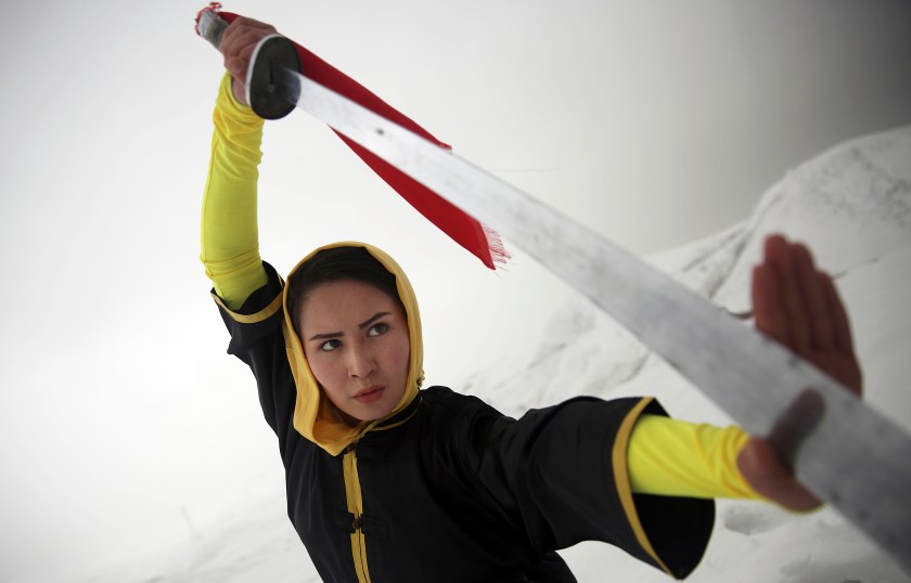 Shaolin martial arts trainer, Sima Azimi, 20, performs on a hilltop in Kabul, Afghanistan, Tuesday, Jan. 25, 2017. Azimi said it was difficult to find all the tools needed to train. For instance, she had to order her Shaolin sword from Iran, where she had studied the art for three years. (AP Photos/Massoud Hossaini)
