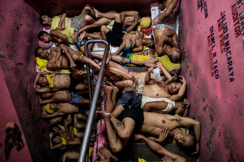General News - Third Prize, Singles: The photos show scenes from Quezon City Jail, one of the Philippines' most overcrowded prisons. Conditions are getting worse as police wage an unprecedented war on crime. There are 3,800 inmates at the jail, which was built six decades ago to house 800, and they engage in a relentless contest for space. Men take turns to sleep on the cracked cement floor of an open-air basketball court, the steps of staircases, underneath beds and hammocks made out of old blankets. In this photo taken on July 21, 2016, inmates sleep on the steps of a ladder inside the Quezon City jail at night in Manila. (Noel Celis/Agence France-Presse)