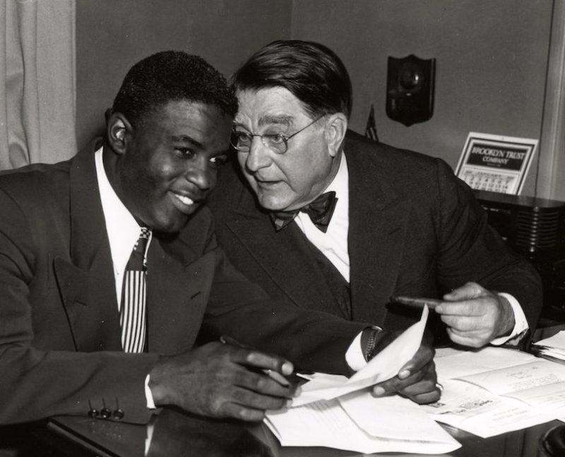 BROOKLYN - 1949. Jackie Robinson, left, and Branch Rickey share a joke during a contract signing session in the front offices of the Brooklyn Dodgers at Ebbets Field in Brooklyn in 1949. (Photo by Mark Rucker/Transcendental Graphics, Getty Images)