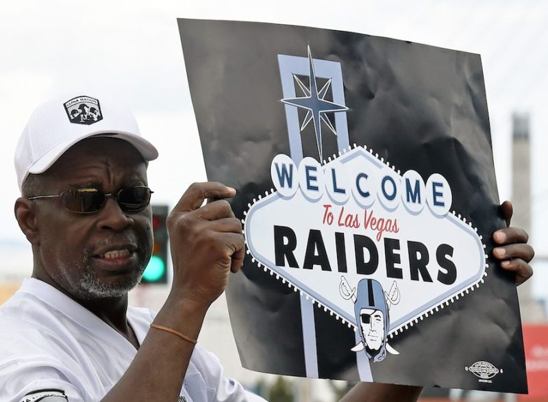 LAS VEGAS, NV - MARCH 27: Oakland Raiders fan Davi Tole of Nevada displays a sign to passing motorists on the Las Vegas Strip near the Welcome to Fabulous Las Vegas sign after National Football League owners voted 31-1 to approve the team's application to relocate to Las Vegas during their annual meeting on March 27, 2017 in Las Vegas, Nevada. The Raiders are expected to begin play no later than 2020 in a planned 65,000-seat domed stadium to be built in Las Vegas at a cost of about USD 1.9 billion. (Photo by Ethan Miller/Getty Images)