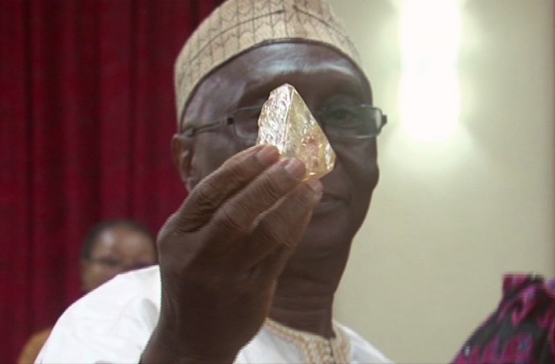 In this photo taken from video footage, Sierra Leone's Minister of Mines and Mineral Resources Alhaji Minkailu Mansaray hands a diamond during a meeting with delegates of Kono district, where the gem was found, at the presidential office in Freetown, Sierra Leone, Thursday, March 16, 2017. A pastor in Sierra Leone has discovered the largest uncut diamond found in more than four decades in this West African country and has turned it over to the government, saying he hopes it helps to boost recent development in his impoverished nation. (SLBC via AP)