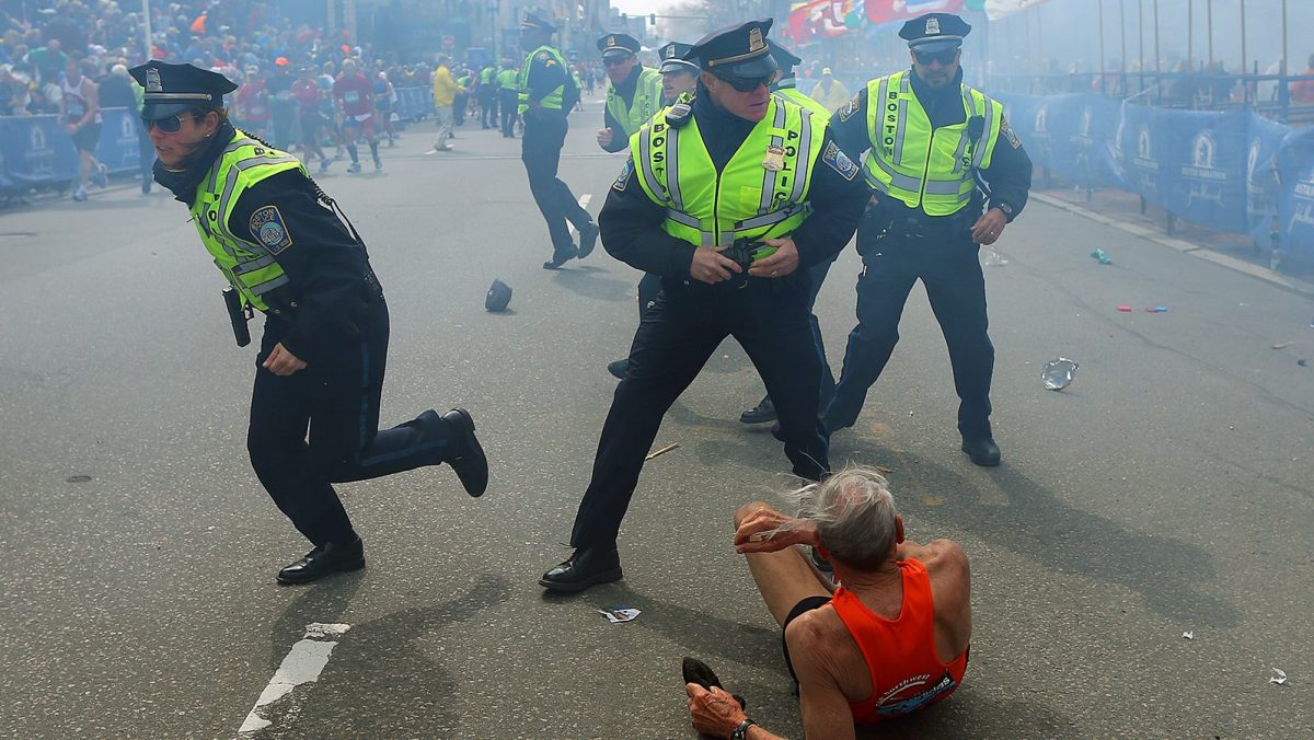 BOSTON - APRIL 15: Police officers with their guns drawn hear the second explosion down the street. The first explosion knocked down 78-year-old US marathon runner Bill Iffrig at the finish line of the 117th Boston Marathon. (Photo by John Tlumacki/The Boston Globe via Getty Images)