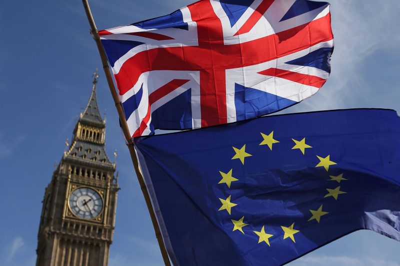 An EU flag and a Union flag held by a demonstrator is seen with Elizabeth Tower (Big Ben) and the Houses of Parliament as marchers taking part in an anti-Brexit, pro-European Union (EU) enter Parliament Square in central London on March 25, 2017, ahead of the British government's planned triggering of Article 50. (Daniel Leal-Olivas/AFP/Getty Images)