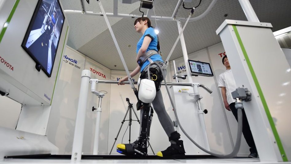 A model demonstrates how the rehabilitation-assist robot Welwalk WW-1000, developed by Japan's Toyota Motor Corporation, helps to assist in flexing and extending the knee while walking on a treadmill during a press preview in Tokyo on April 12, 2017.
(Kazuhiro Nogi/AFP/Getty Images)