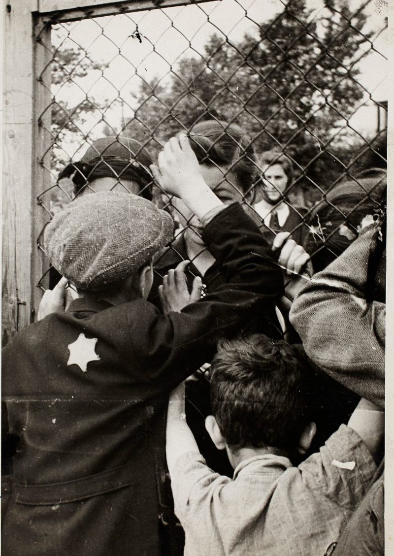 Lodz ghetto: Children talking through fence of central prison on Czarnecki Street prior to deportation (Henryk Ross/Art Gallery of Ontario)