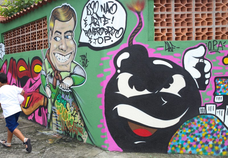 Graffiti is displayed on a wall depicting Joao Doria, mayor of Sao Paulo, sweeping local street art under a rug in Sao Paulo, Brazil (Patricia Monteiro/Bloomberg)