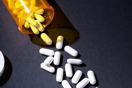 Pills spilling out of a prescription bottle.