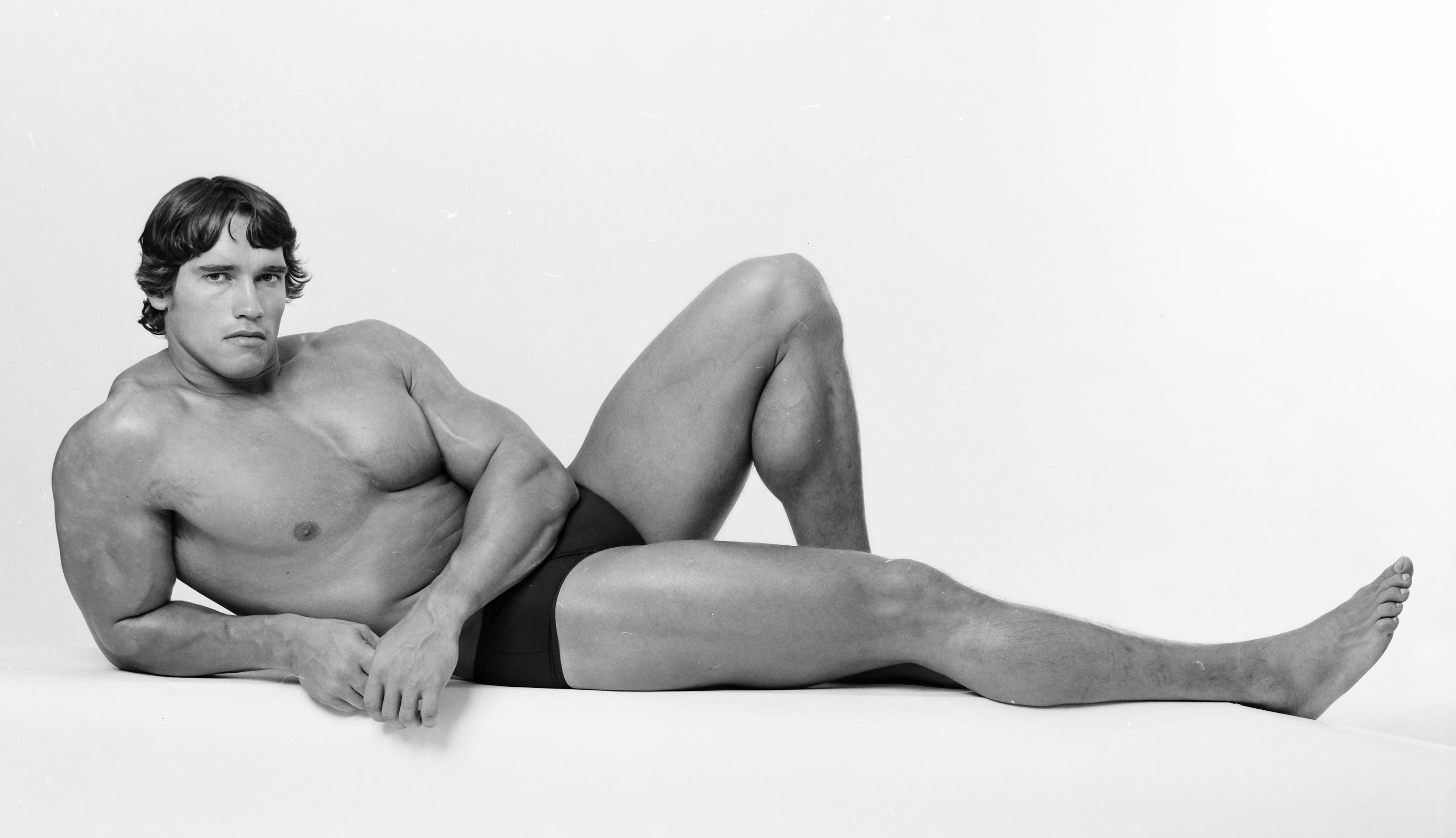 Professional bodybuilder Arnold Schwarzenegger posing at the top of his for...