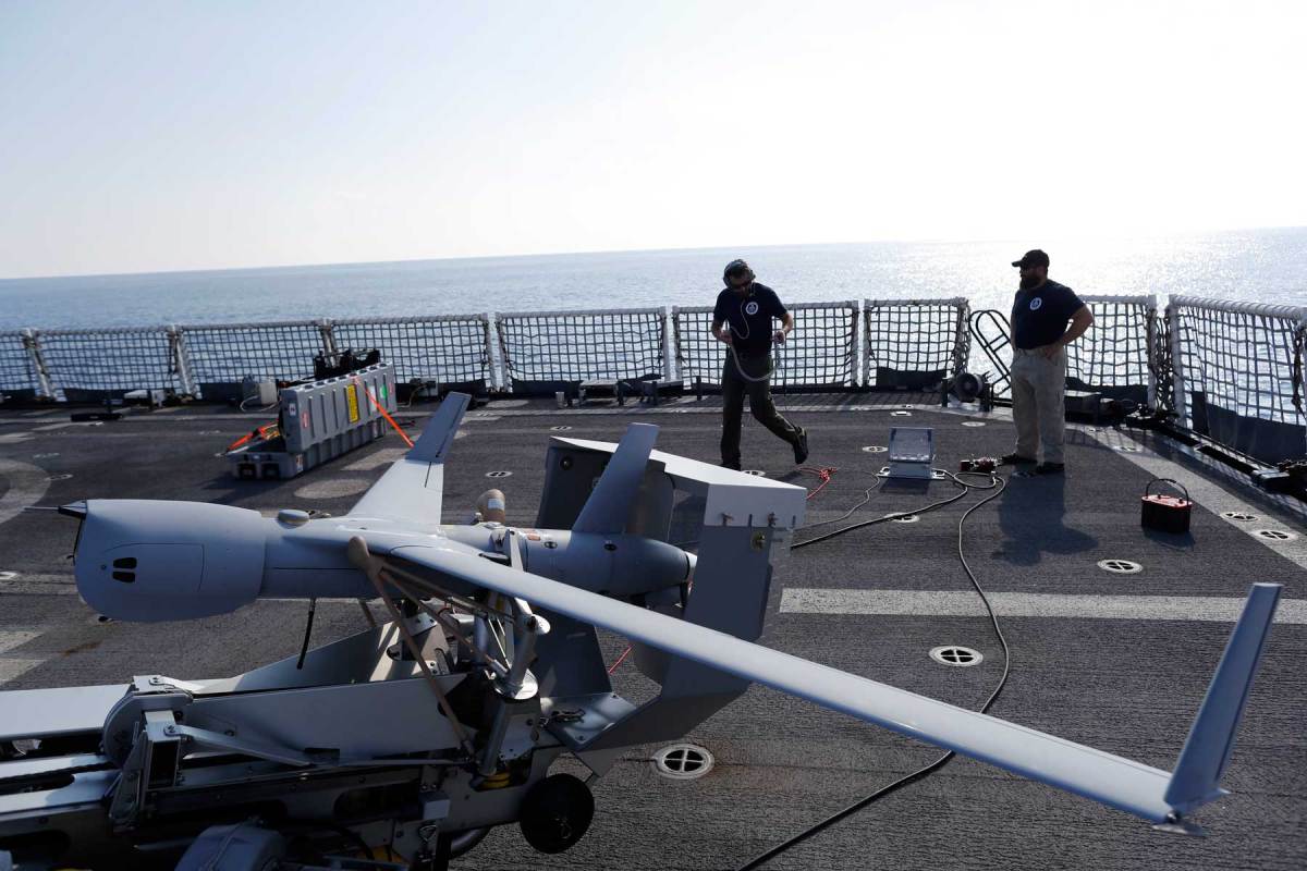 Technicians prepare the ScanEagle unmanned aerial vehicle prior to take off from the flight deck of the U.S. Coast Guard cutter Stratton somewhere in the eastern Pacific Ocean. (AP Photo/Dario Lopez-Mills)
