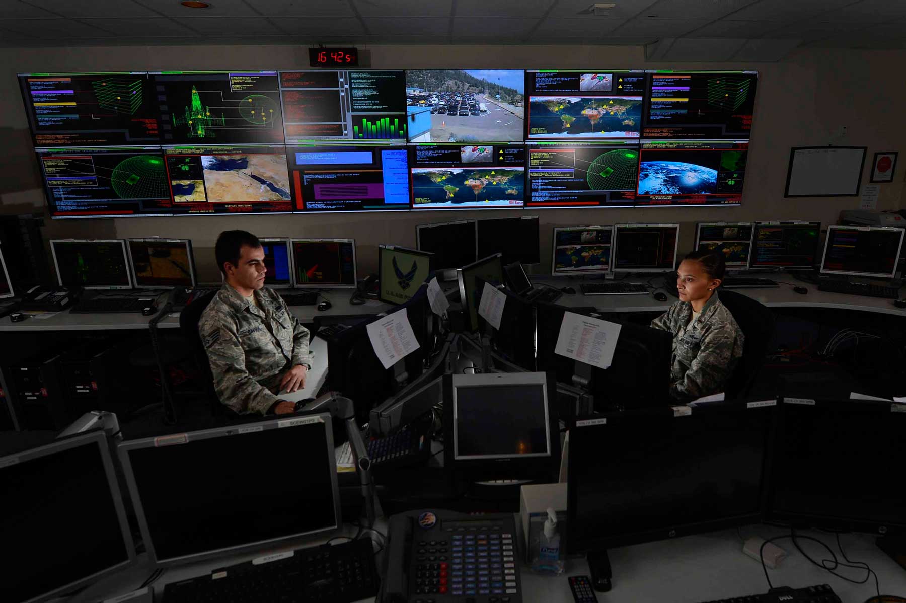 Staff Sgt. Alex Garviria and 2nd Lt. Rachel James work in the Global Strategic Warning and Space Surveillance System Center Sept. 2, 2014, at Cheyenne Mountain Air Force Station, Colo. Garviria is a 721st CS senior systems controller and James is the 721st CS crew commander. (U.S. Air Force photo by Airman 1st Class Krystal Ardrey/Released)