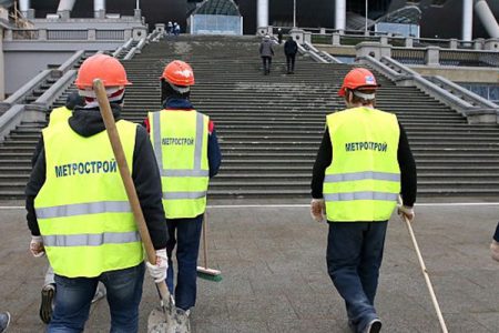 Construction workers walking to Zenit Arena Stadium, one of the venues for the 2018 World Cup in Russia.