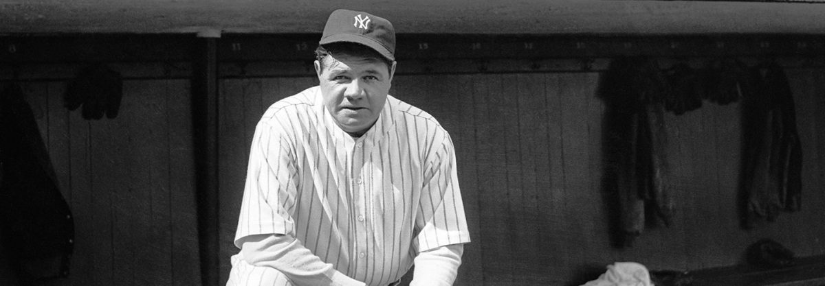 Babe Ruth in his Yankees uniform stands on dugout steps