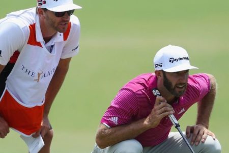 Dustin Johnson and his brother/caddie Austin line up a putt at THE PLAYERS Championship on May 12, 2017. (Warren Little/Getty Images)