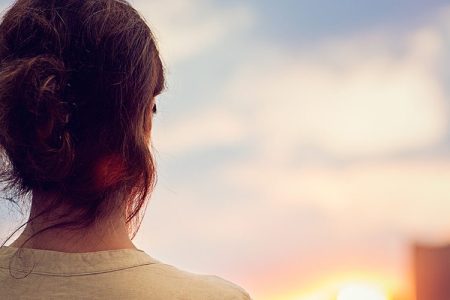Young girl is watching sunset over Tokyo in Odaiba.
