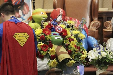 Dale Hall, dressed as Superman, stands before the casket during a superhero-themed funeral service for his brother, Jacob Hall at Oakdale Baptist Church on Wednesday, Oct. 5, 2016, in Townville, S.C.