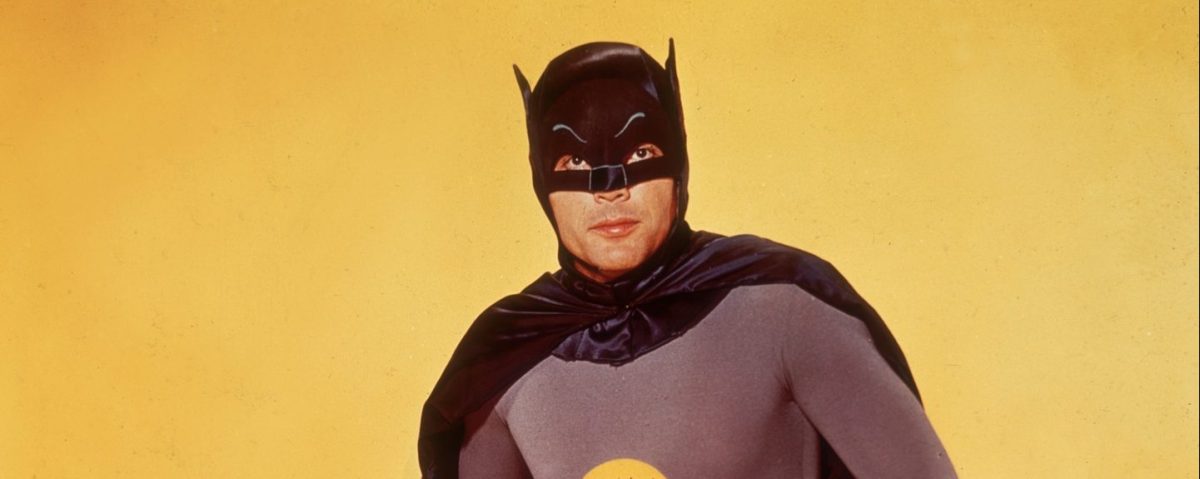 Actor Adam West poses in costume as Batman in front of a yellow backdrop in a promotional portrait for the television series, 'Batman'. (Photo by Hulton Archive/Getty Images)
