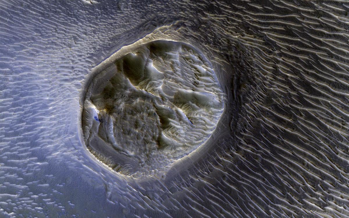 This image from NASA's Mars Reconnaissance Orbiter shows a small (0.4 kilometer) mesa, one of several surrounded by sand dunes in Noctis Labyrinthyus, an extensively fractured region on the western end of Valles Marineris. (NASA/Mars Reconnaissance Orbiter)