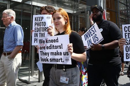 New York Times (NYT) employees hold banners during a temporary strike against downsizing and dismissal plans of the NYT management outside of New York Times building in New York, United States on June 29, 2017.