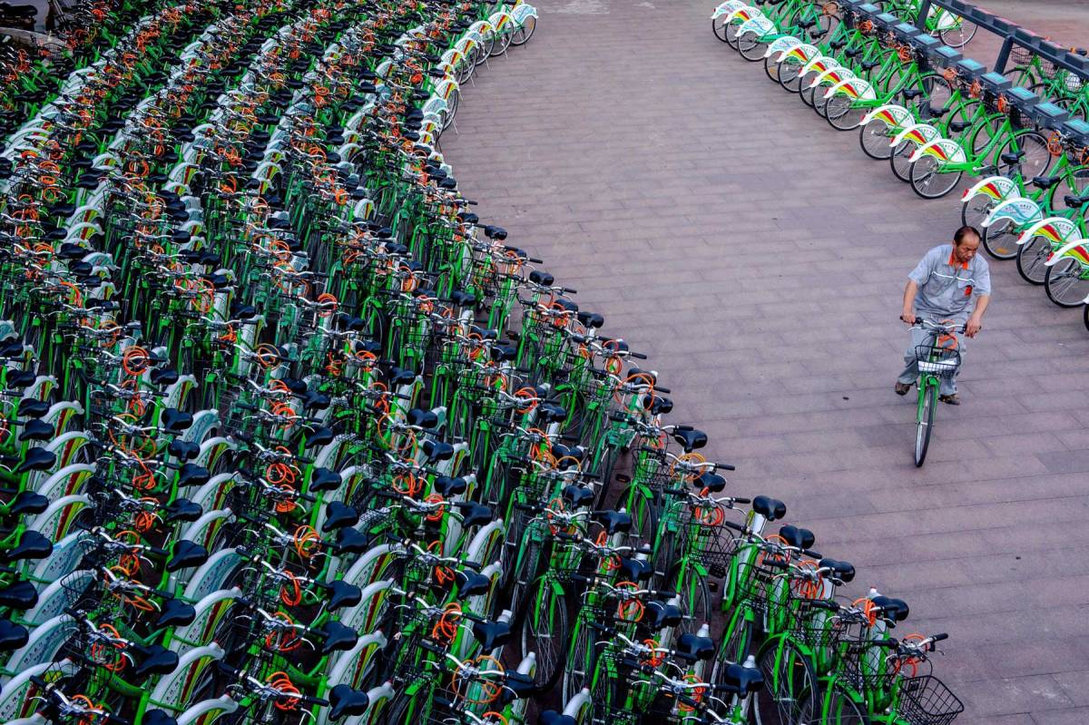 This picture taken on June 14, 2014 shows a man rising a public bicycle through a bicycle-sharing station in Beijing. (AFP/Getty Images)