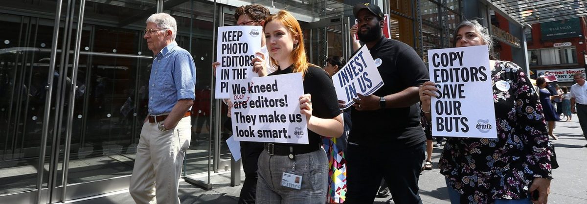 New York Times (NYT) employees hold banners during a temporary strike against downsizing and dismissal plans of the NYT management outside of New York Times building in New York, United States on June 29, 2017.