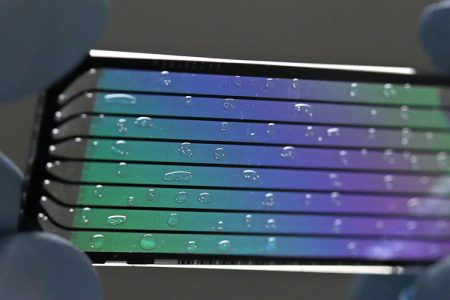 John D'Albora, 41, a senior research technician, holds up a used flow cell to display its intricacies at the Genome Institute at Washington University on Thursday, April 23, 2015. A flow cell holds the DNA for the sequencing machine.