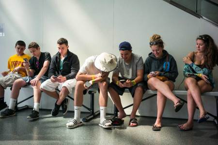 Teens look at their iPhones July 3, 2015 at the Rock and Roll Hall of Fame in Cleveland, Ohio. (Robert Nickelsberg/Getty Images)