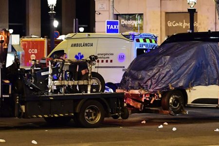 The van who ploughed into the crowd, killing at least 13 people and injuring around 100 others is towed away from the Rambla in Barcelona on August 18, 2017.
