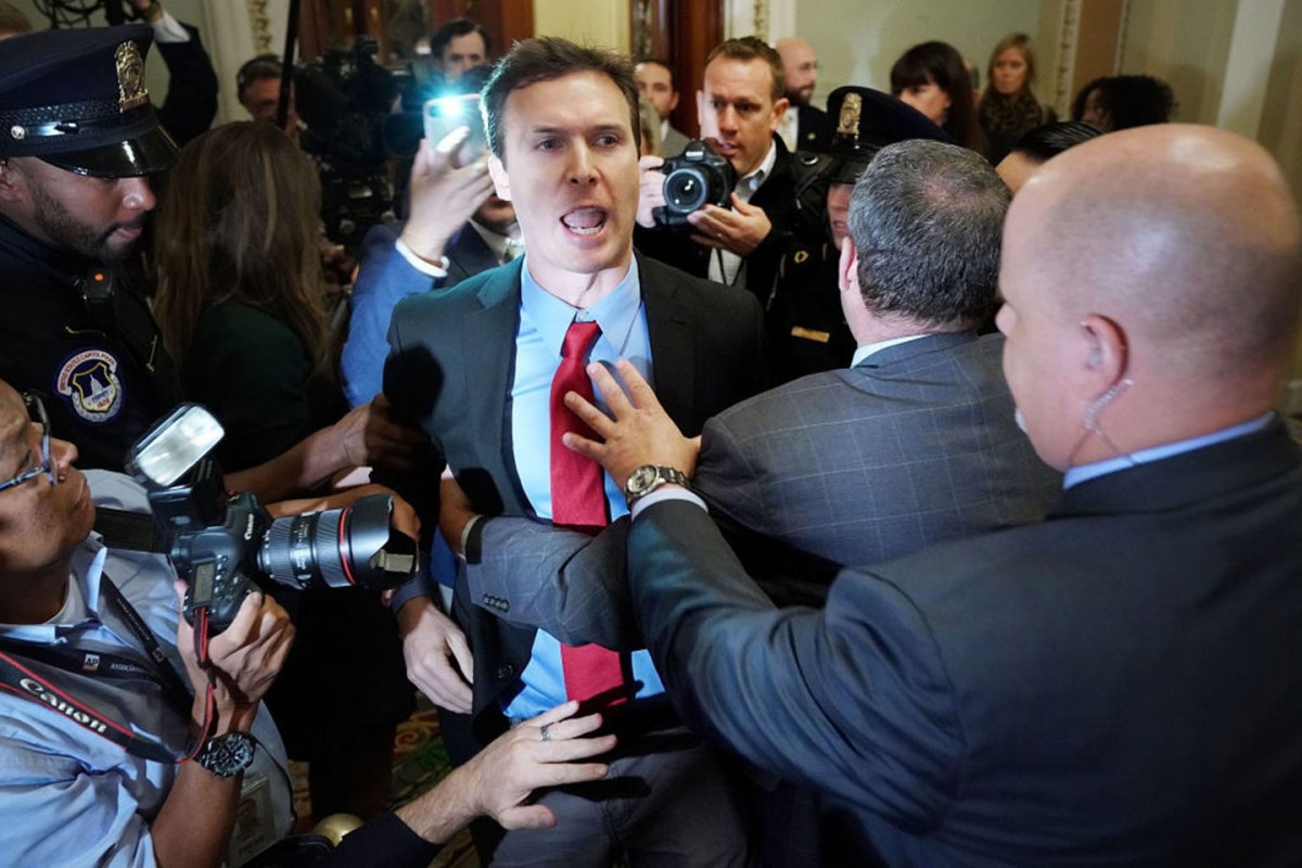 Ryan Clayton of Americans Take Action (C) is corralled by police after he threw paper Russian flags at Senate Majority Leader Mitch McConnell (R-KY) and U.S. President Donald Trump as they arrived for the Republican Senate Policy Luncheon at the U.S. Capitol October 24, 2017 in Washington, DC. Trump joined the senators to talk about upcoming legislation, including the proposed GOP tax cuts and reform. (Photo by Chip Somodevilla/Getty Images)