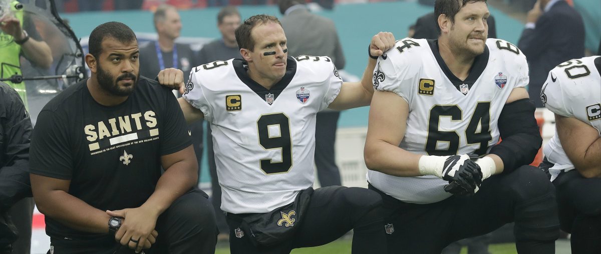 New Orleans Saints quarterback Drew Brees (9) kneels down with teammates before the U.S. national anthem was played ahead of an NFL football game against the Miami Dolphins at Wembley Stadium in London, Sunday Oct. 1, 2017. Saints players then stood when the anthem was played. (AP Photo/Tim Ireland)