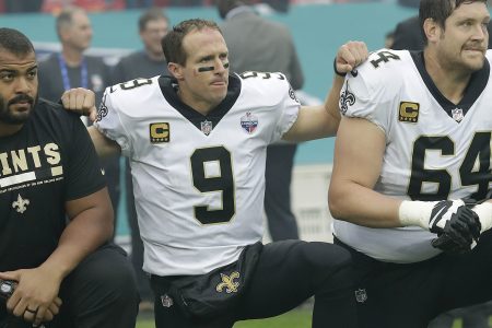 New Orleans Saints quarterback Drew Brees (9) kneels down with teammates before the U.S. national anthem was played ahead of an NFL football game against the Miami Dolphins at Wembley Stadium in London, Sunday Oct. 1, 2017. Saints players then stood when the anthem was played. (AP Photo/Tim Ireland)
