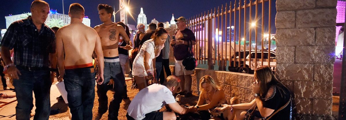 People tend to the wounded outside the Route 91 Harvest Country music festival grounds after an apparent shooting on October 1, 2017 in Las Vegas, Nevada. There are reports of an active shooter around the Mandalay Bay Resort and Casino. (Photo by David Becker/Getty Images)
