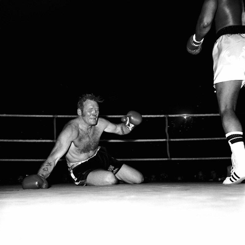 Richard Dunn grimaces as he hits the canvas again, one of five knockdowns he suffered during his 1976 fight against Muhammad Ali, one of boxing's great mismatches.  (PA Images via Getty Images)