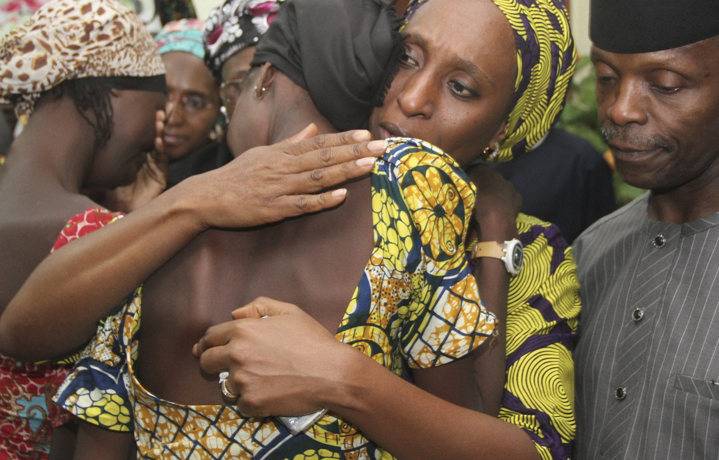 Nigerian Vice President Yemi Osinbajo (R) looks on while his wife Dolapo (C) comforts one of the 21 freed Chibok girls freed today from Boko Haram, at his office in Abuja on October 13, 2016.      (PHILIP OJISUA/AFP/Getty Images)