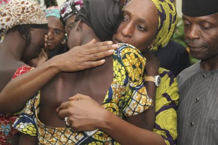 Nigerian Vice President Yemi Osinbajo (R) looks on while his wife Dolapo (C) comforts one of the 21 freed Chibok girls freed today from Boko Haram, at his office in Abuja on October 13, 2016.      (PHILIP OJISUA/AFP/Getty Images)