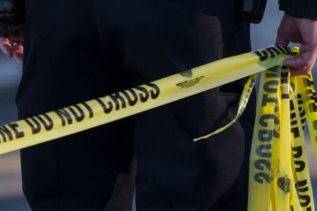 A police officer pulls crime scene tape at a house where a double homicide was being investigated in Peabody, MA on Feb. 19, 2017. (Keith Bedford/The Boston Globe via Getty Images)