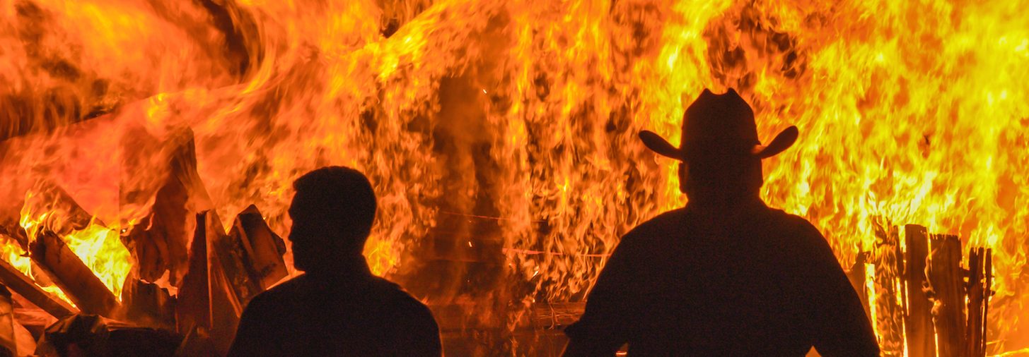 Investigators Kris Coughlin (left) and Randy Patrick of the series "KILLING FIELDS: Murder Isle" walk away from a burning house. (Courtesy of Discovery)