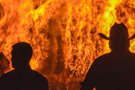 Investigators Kris Coughlin (left) and Randy Patrick of the series "KILLING FIELDS: Murder Isle" walk away from a burning house. (Courtesy of Discovery)