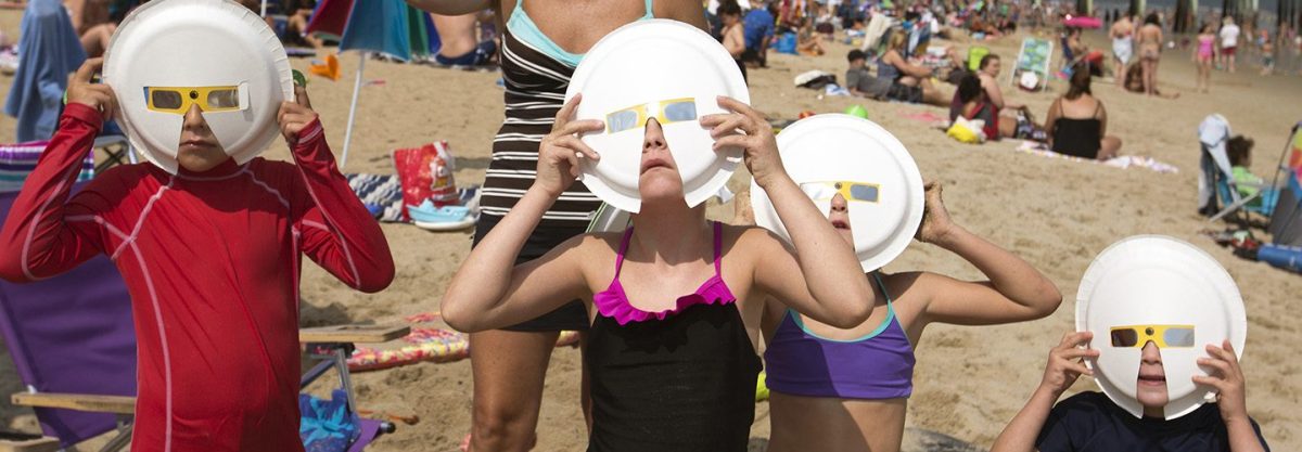 Members of two vacationing families observe the partial solar eclipse at through some hand-improved solar glasses fat Old Orchard Beach. From left: Paul Scango, Katie Vanlandingham (cq), Samantha Scango, Avery Vanlandingham and Quinn Vanlandingham. (Ben McCanna/Portland Press Herald via Getty Images)