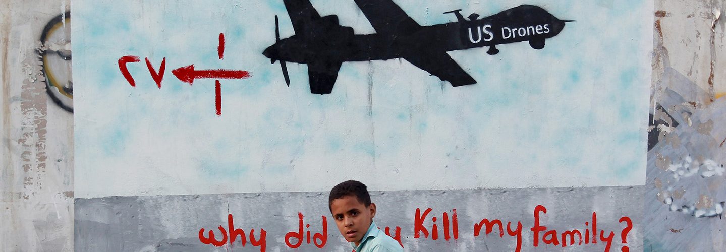 A Yemeni boy (C) walks past a mural depicting a US drone and reading " Why did you kill my family" on December 13, 2013 in the capital Sanaa. (MOHAMMED HUWAIS/AFP/Getty Images)
