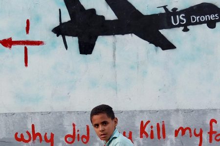 A Yemeni boy (C) walks past a mural depicting a US drone and reading " Why did you kill my family" on December 13, 2013 in the capital Sanaa. (MOHAMMED HUWAIS/AFP/Getty Images)