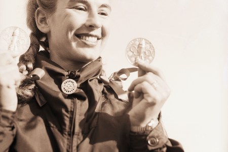 Gretchen Fraser displays the two medals she won in Olympic skiing events. One medal was for placing 2nd in the alpine combined downhill and the other was 1st prize in the special Woman's slalom. Fraser became the first American ever to win an individual skiing championship in the history of the Olympic games.