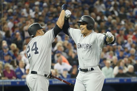 Giancarlo Stanton #27 of the New York Yankees is congratulated by Gary Sanchez #24 after hitting a two-run home run in the first inning on Opening Day during MLB game action against the Toronto Blue Jays at Rogers Centre on March 29, 2018 in Toronto, Canada. (Photo by Tom Szczerbowski/Getty Images)