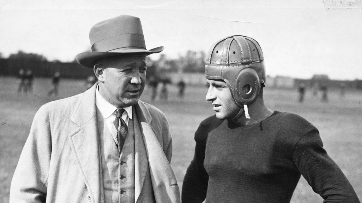 Notre Dame football coach Knute Rockne talks with a player. (George Rinhart/Corbis via Getty Images)