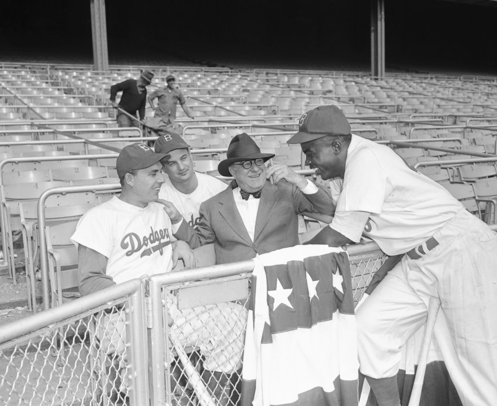 The Dodgers at Yankee Stadium are shown with left to right Gil Hodges, Gene Hermanski, Branch Rickey, and Jackie Robinson, during the World Series.