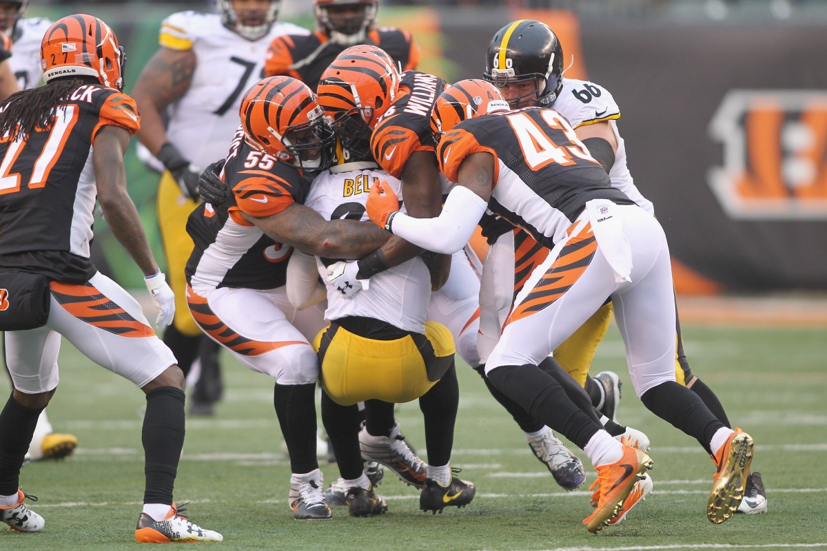 Le'Veon Bell #26 of the Pittsburgh Steelers runs the football upfield against Vontaze Burfict #55 and George Iloka #43 of the Cincinnati Bengals during their game at Paul Brown Stadium on December 18, 2016 in Cincinnati, Ohio.The Steelers defeated the Bengals 24-20.  (Photo by John Grieshop/Getty Images)