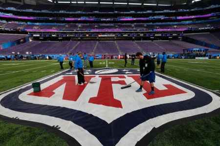 Workers clean the NFL logo at midfield at US Bank Stadium. Bill Greene/Globe Staff)